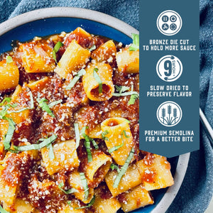 Prepared Sfoglini Rigatoni pasta with tomato sauce and basil on a dish. With product feature icons and text - Bronze die cut to hold more sauce. Slow dried to preserve flavor. Premium semolina for a better bite.