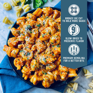 Prepared Sfoglini Vesuvio by Sporkful pasta with creamy red sauce on a dish. With product feature icons and text - Bronze die cut to hold more sauce. Slow dried to preserve flavor. Premium semolina for a better bite.