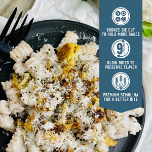 Prepared Sfoglini Whole Grain Radiators pasta with cauliflower sauce on a dish. With product feature icons and text - Bronze die cut to hold more sauce. Slow dried to preserve flavor. Premium semolina for a better bite.