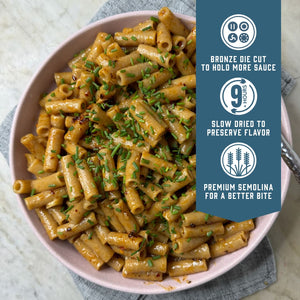 Prepared Sfoglini Whole Grain Einkorn Ziti pasta on a dish. With product feature icons and text - Bronze die cut to hold more sauce. Slow dried to preserve flavor. Premium semolina for a better bite.
