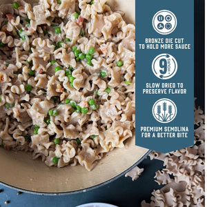 Prepared Whole Grain Reginetti pasta with green peas in a pot. Blue banner with product feature icons and text - Bronze die cut to hold more sauce. Slow dried to preserve flavor. Premium semolina for a better bite.