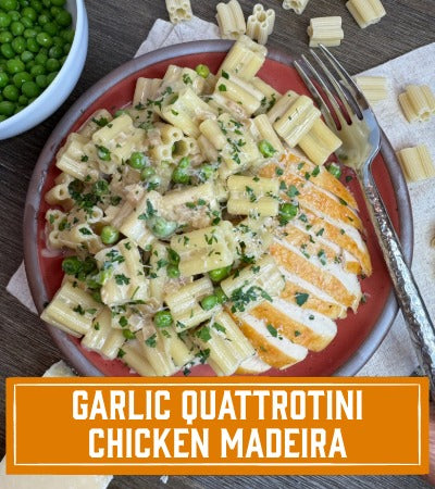 Garlic Quattrotini Chicken Madeira dish on a plate with peas and pasta.