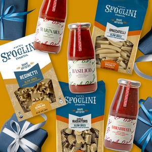 Packages of Sfoglini Classic Italian Pantry Set with Spacatelli, Reginetti, and Garlic Radiators pasya packaging and Marinara, Basilico, and Arrabiata sauce jars on a yellow background
