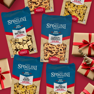 The Limited-Edition Sporkful Collection package with Calabrian Chili Cascatelli, Garlic Quattrotini, and Saffron Vesuvio pasta bags on red background