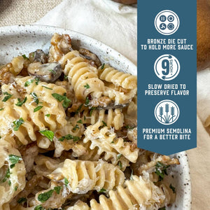 Whole Grain Radiators pasta with creamy mushrooms and herbs served in a speckled bowl.  Blue banner with product feature icons and text - Bronze die cut to hold more sauce. Slow dried to preserve flavor. Premium semolina for a better bite.